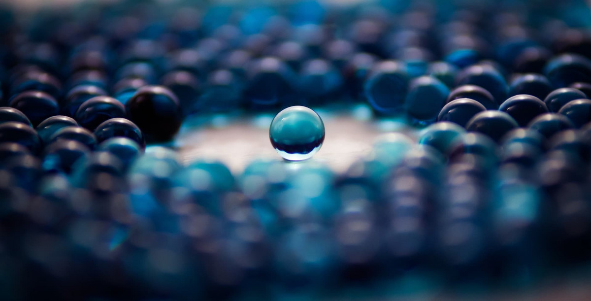 Camera focused on a single marble, singled out from other marbles surrounding it