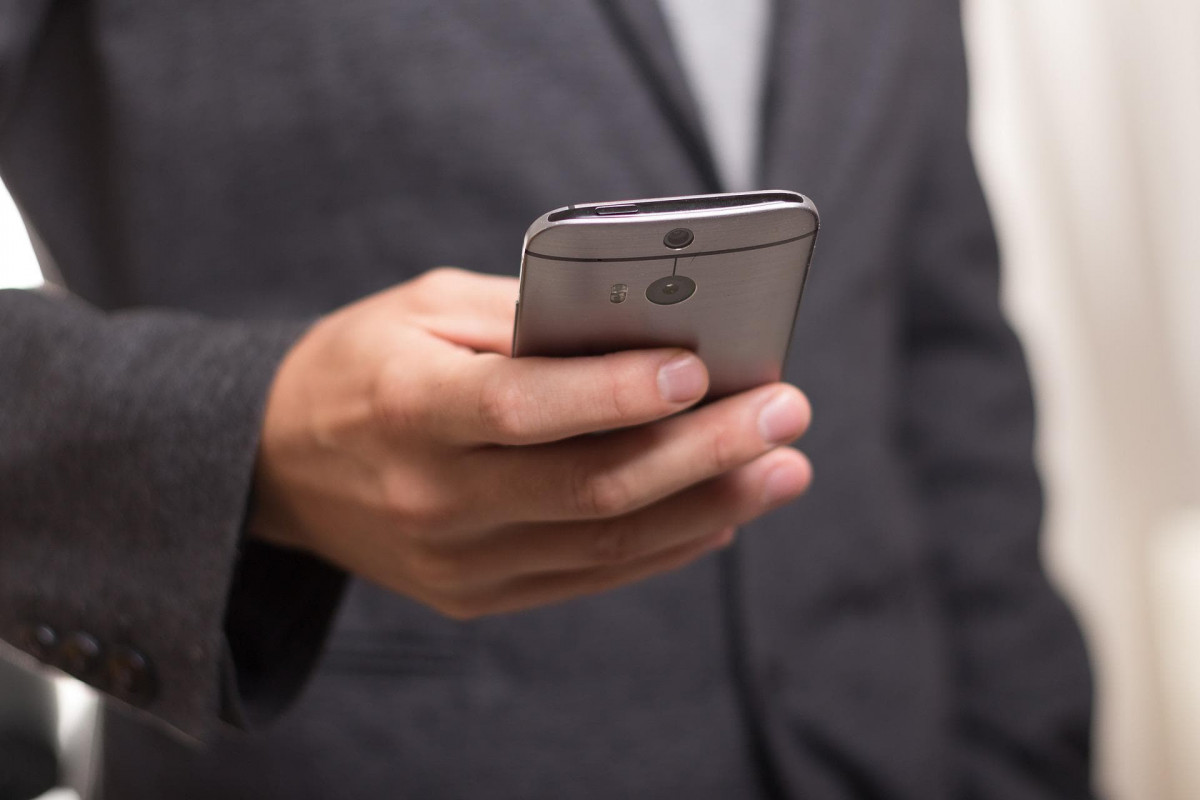 Person in a business suit holding a phone